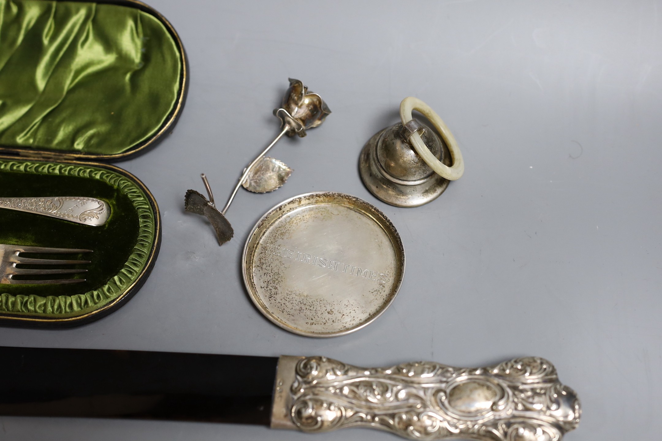 A late Victorian repousse silver mounted tortoiseshell page turner (chip), 39.6cm, a silver rattle, a silver the Irish Times pin tray, 800 standard model of a rose and a cased silver christening pair.